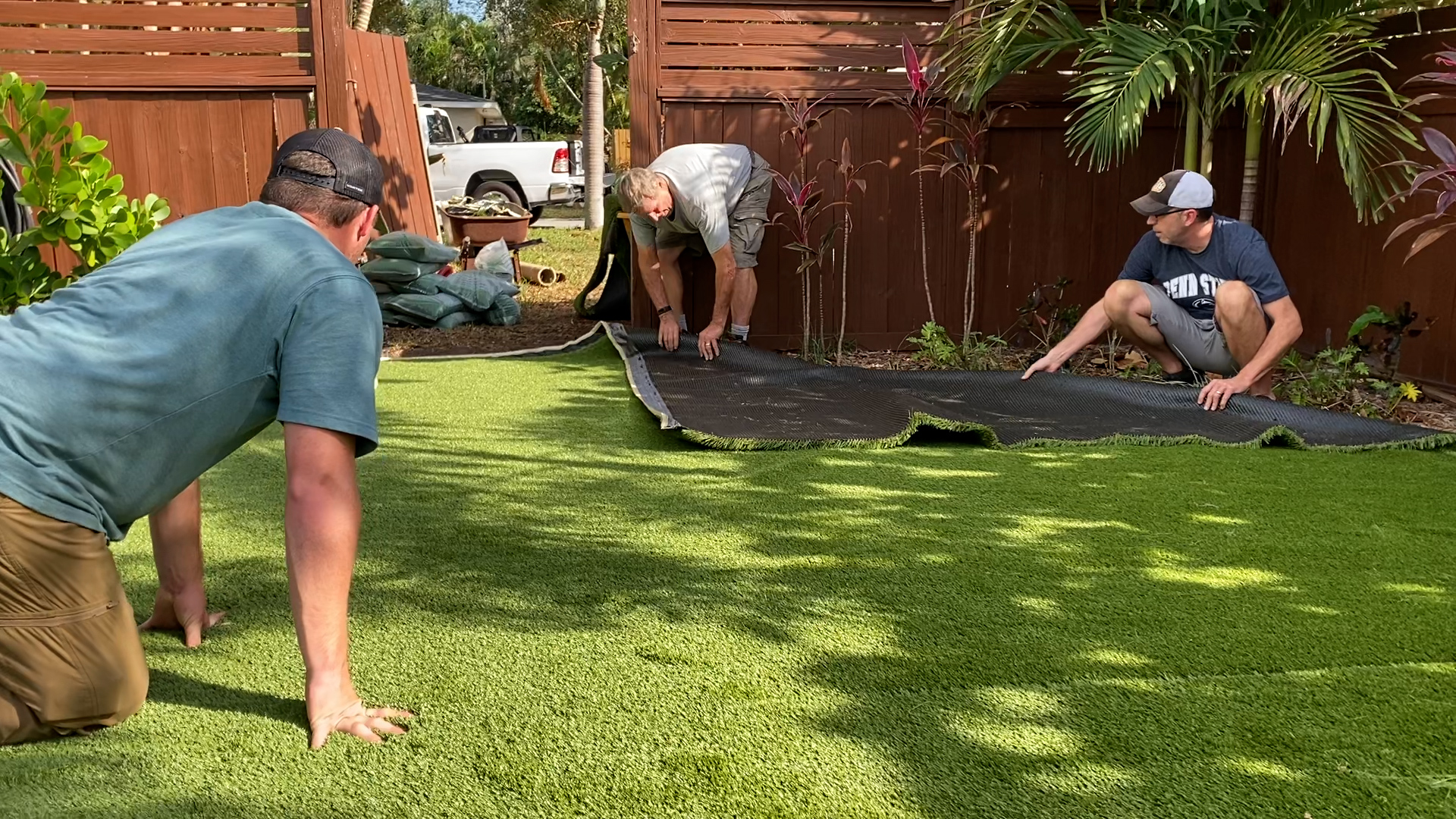 Artificial turf crew installing grass in a backyard / Cuadrilla instalando césped artificial en campo residencial